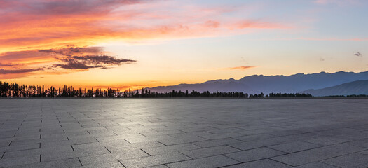 Empty square floor and mountains at sunrise. Road and sky background.