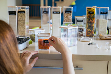 Closeup female hands applying printing sticker with name red lentils on transparent plastic case box