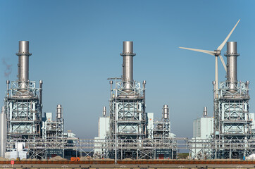 Modern multi-fuel power station and a wind turbine in a seaport.