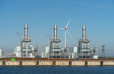 Modern multi-fuel power station and a wind turbine in a seaport.