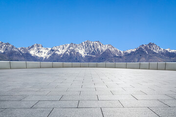 Empty square floor and mountains under blue sky. Road and mountain background.