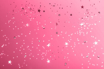 Beautiful festive pacific pink background with confetti. Top view. Color trend concept.