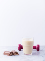 Banana coconut smoothie and protein bar on bright stone background. Soft focus. Copy space.