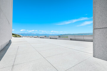 Empty square floor and mountains under blue sky