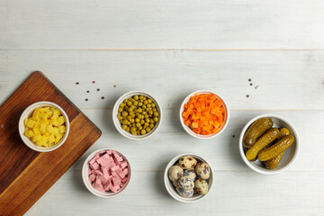 Ingredients for making Olivier salad. Top view on a light wooden background, with a copy of the space.