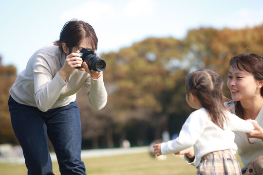 親子の写真を撮る女性カメラマン