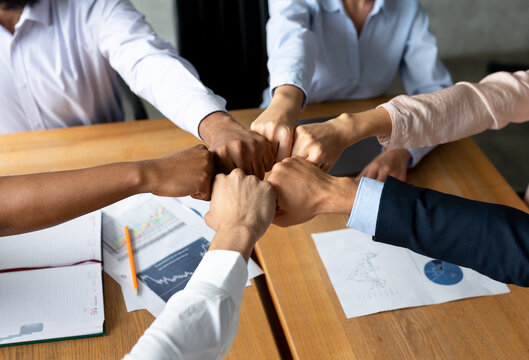 Business Team Unity. Group Of Multiethnic Colleagues Joining Fists Together In Office