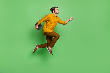 Fototapeta na wymiar Full size profile photo of cool millennial hr guy run with laptop wear eyesight shirt pants shoes isolated on green background