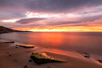 Fototapeta na wymiar Exciting long exposure red sunrise over the sea.