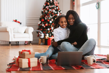 Portrait of happy black family watching movie on laptop