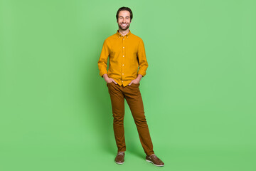 Full size photo of optimistic young guy pose wear shirt trousers footwear isolated on green color background