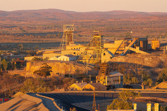 Elevated view of a working mine and surrounding hills in the outback at sunset