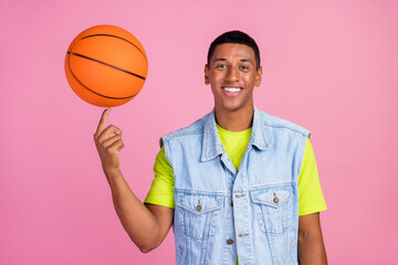 Photo of cool young brunet guy play basketball wear t-shirt vest jeans isolated over pink color...