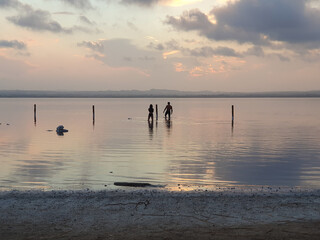Naklejka premium Vega Baja del Segura - Torrevieja - Paisajes y reflejos de siluetas en el lago salado al atardecer en las salinas 