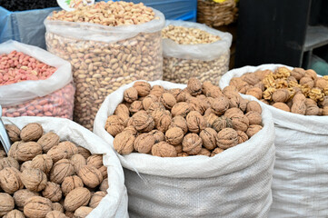Walnuts and dried fruits on market stall. Bag full of walnuts in shop. Food on Bazaar.