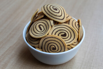 Kue Kuping Gajah, traditional cookies from Indonesia. Sweet and crunchy, unique spiral pattern. Wooden background.