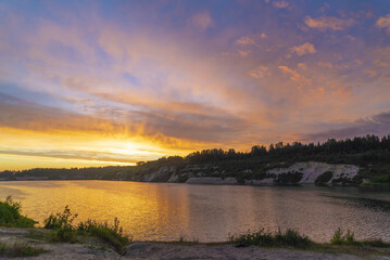 Fototapeta na wymiar Sunset in the cloudy sky over the Pugorevsky quarry. Vsevolozhsk. Leningrad region