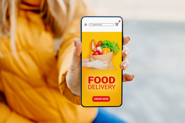 delivery of food app. Female hand shows the screen of a mobile phone with an application about the...