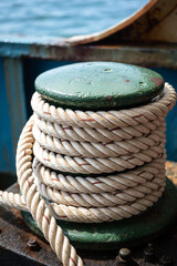 Fototapeta na wymiar Nautical vessel heavy rope which is rolled in metal drum, this rope will anchor for stability when the ship is docking at harbour. Transportation equipment object photo, selective focus.