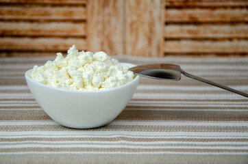 fresh homemade cottage cheese in white cup. Delicious healthy breakfast. Close-up. Rustic still life