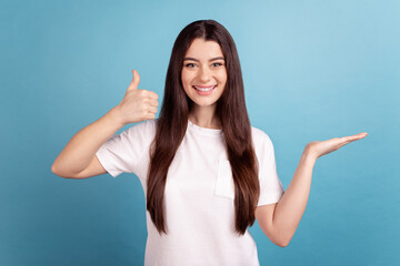 Photo of young cheerful woman show thumb-up recommend prodcut offer discount isolated over blue color background