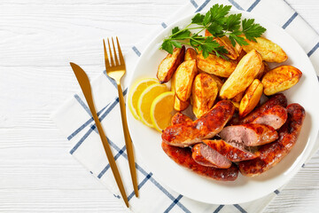 fried sausages on a plate with potatoes