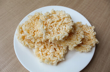 Rengginang, traditional crackers from Indonesia, made from sticky rice which dried then fried. On a white plate.