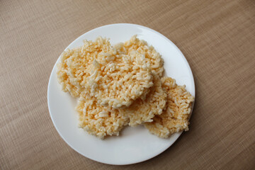 Rengginang, traditional crackers from Indonesia, made from sticky rice which dried then fried. On a white plate.