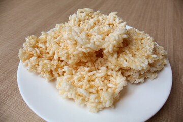 Rengginang, traditional crackers from Indonesia, made from sticky rice which dried then fried. On a white plate.
