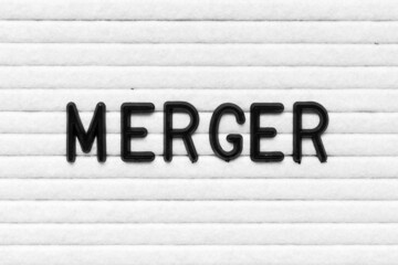 Black alphabet letter in word merger on white felt board background