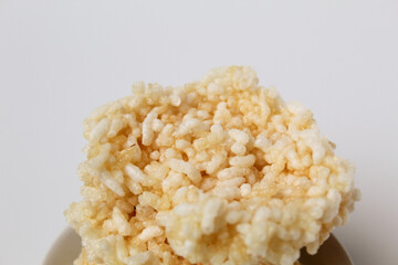 Rengginang, traditional crackers from Indonesia, made from sticky rice which dried then fried. On a white plate. Isolated on white background.