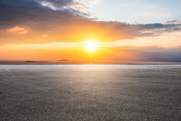 Asphalt road and sea scenery at sunrise, road and sky background.