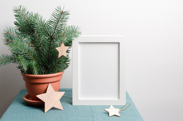 Christmas frame mockup with fir tree branches in terracotta pot an wooden stars decorations