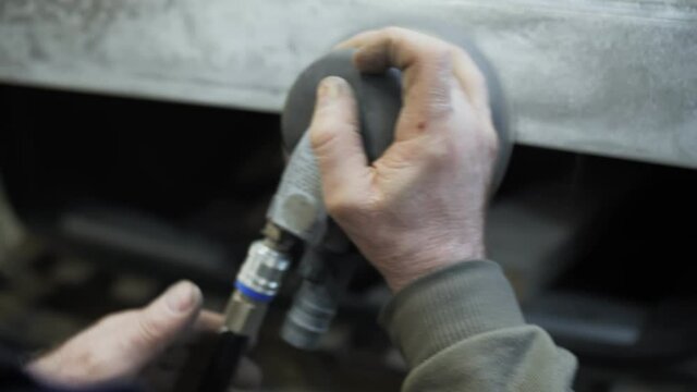 polishing of the damaged car door with a grinder