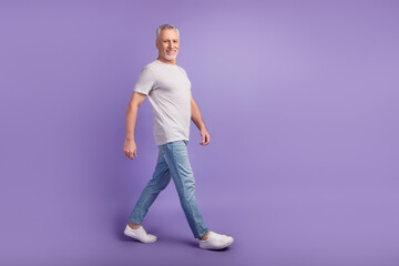 Profile side photo of handsome man go walk empty space wear casual outfit isolated over violet color background