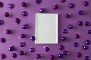 White frame on a purple background made of Christmas bubbles decoration. Magnetic. 