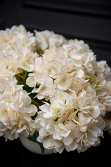Plastic handmade bouquet artificial flowers composition.Beautiful flowers in vase on a table with black  background. Women's, mother's day. Spring, summer season. Front view.Selective focus.
