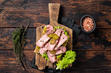 Beef Steak sandwich with sliced griiled beef, salad and vegetables on bread. Wooden background. Top view
