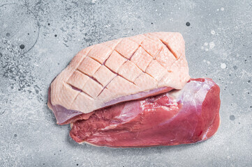 Duck breast fillet on butcher table, raw poultry meat. Gray background. Top view