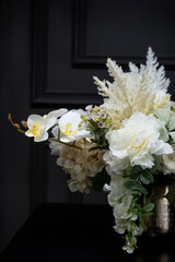 Plastic handmade bouquet artificial flowers composition.Beautiful flowers in vase on a table with black  background. Women's, mother's day. Spring, summer season. Front view.Selective focus.
