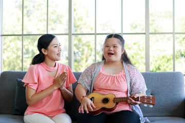 happy family mother with the cute girl who is a star Sildom sitting on the guitar Singing in the...