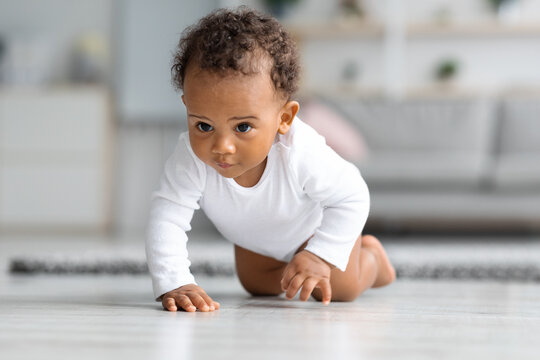 Closeup Portrait Of Cute Black Infant Baby Crawling On Floor At Home