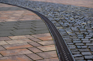 gray andbrown cube granite cobblestone pavement. rectangular shapes loosely set. cement mortar...