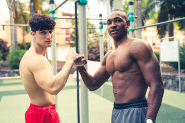 Fototapeta na wymiar Two young friends after training in open-air calisthenics. Muscular boys after exercising. Outdoor gym. Hobby.