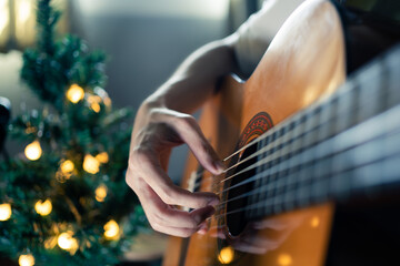 Playing classical guitar in Christmas day - obrazy, fototapety, plakaty