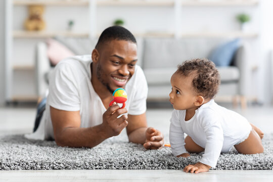Leisure With Babies. Happy Black Dad Playing Toys With His Infant Child