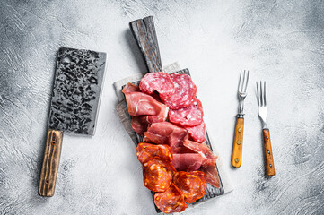 Assorted meat appetizers - salami, jamon, choriso sausages. White background. Top view