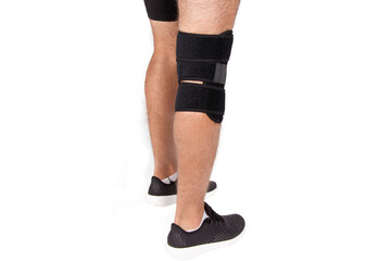 Knee Support Brace on leg isolated on white background. Orthopedic Anatomic. Braces for knee fixation, injuries and pain. Knee Joint Bandage Sleeve. Elastic Sports.