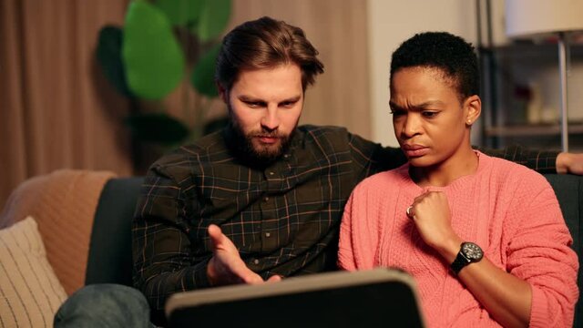 Young puzzled african american lady looking at screen with question. Young worried couple holding their hands on face after they did something wrong. High quality 4k footage