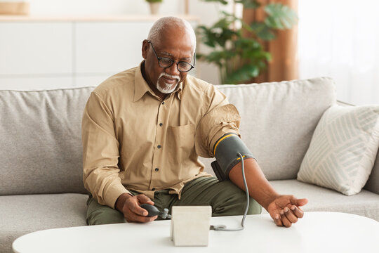 Senior African American Man Measuring Arterial Blood Pressure At Home